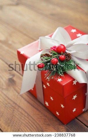 Christmas present wrapped in decorative wrapping paper with  ribbon closeup