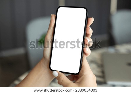 female hand hold phone with isolated screen background table in office