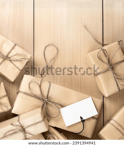 Gift Boxes Wrapped in Brown Recycled Paper With Congratulation on Wooden Table. Copy Space and Holiday Concept