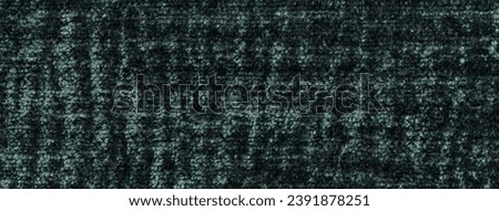 Dark green fluffy background of soft, fleecy cloth. Texture of emerald plush furry textile, closeup.