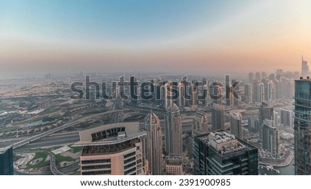 Panorama of Dubai Marina with JLT skyscrapers and golf course during sunset, Dubai, United Arab Emirates. Aerial view from above towers. City skyline with rooftops