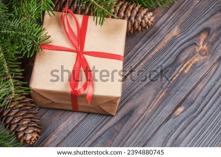 Christmas tree branch, decorations and gift box on white wooden table.