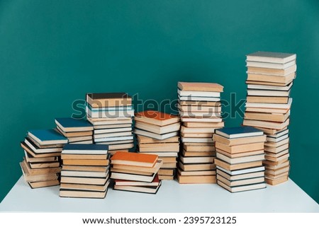 Lots of stacks of old books on green background, school library