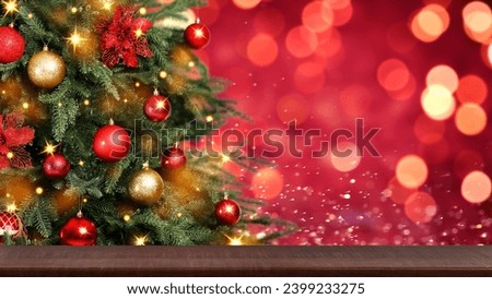 Christmas tree decorated with red and golden balls near wooden table against blurred background. Banner design with space for text