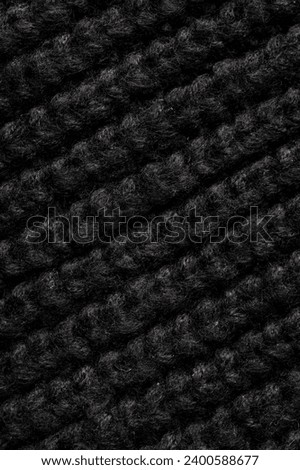 Black knitted fabric as an abstract background. Texture.