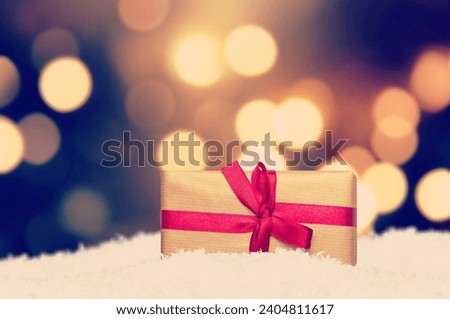 Christmas presents gift box with bow in snow