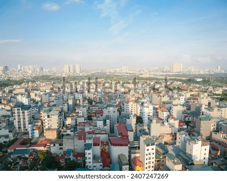 Dense of multistory residential houses with caged balcony and row of high-rise apartment tower complex in background at Van Quan, Ha Dong District, Southwest of Hanoi, Vietnam. Suburban subdivision