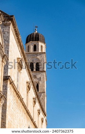  Franciscan Church and Monastery rising above Stradun street and red rooftops in amazing, fortified city of Dubrovnik, Croatia