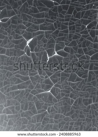 A badly cracked layer of paint on a smooth surface. The cracks formed a beautiful pattern. A photo with a color inversion effect.