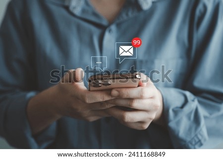 Online communication and email marketing concept. Woman hand using mobile smartphone receive new message and 99 new email alert sign icon pop up.