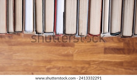 Books are in row on a wooden table. Promotion of books and reading in library