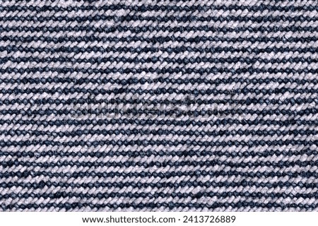 Backside of denim surface, blue jeans fabric, from above. Sturdy cotton warp-faced fabric. Type of textile weave with pattern of diagonal parallel ribs. Indigo dyed warp thread, and white weft thread.