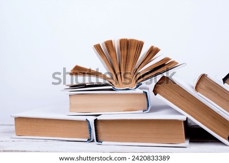 Open books, hardback colorful books on wooden table. orange background. Back to school. Copy space for text. Education business concept