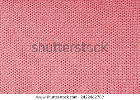 Close up background of knitted wool fabric made of viscose yarn, red color wool knitwear texture. Sweater, pullover knitted jersey background. Fabric abstract backdrop, wallpaper