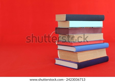 a stack of books against a red wall