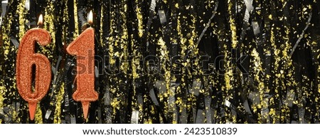 Burning red birthday candles on glitter tinsel background, number 61. Banner. Copy space