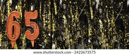 Burning red birthday candles on glitter tinsel background, number 65. Banner. Copy space