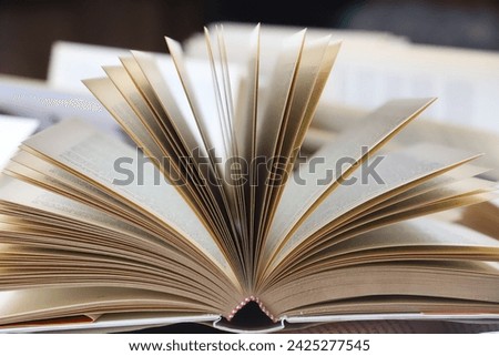 stack of books, close up. Open book on the table in library. Back to school concept. Open book on table with blur bookshelf background