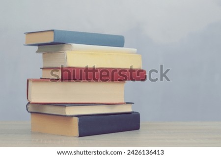 stack of books on white wooden table against white background. space for text