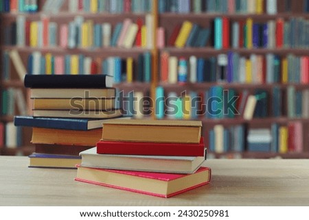 stack of books and glasses on wooden table in library