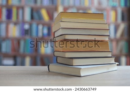 stack of books on wooden table in library