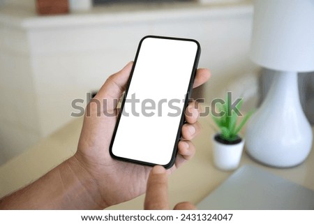 Male hand hold phone with isolated screen background of table at home