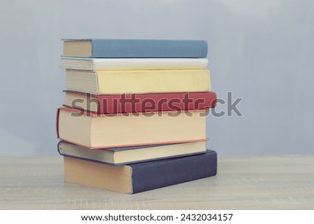stack of books on white wooden table against white background. space for text