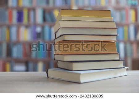 stack of books on wooden table in library