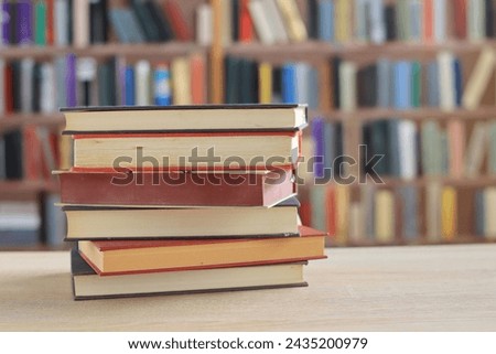 stack of book with red cover on wooden table against blurred background. space for text,a set of books by the world's best writers, photo illustrations for literature, science, learning, studying,