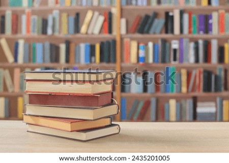 stack of book with red cover on wooden table against blurred background. space for text,a set of books by the world's best writers, photo illustrations for literature, science, learning, studying,