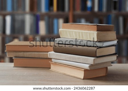 stack of books on wooden table in library, space for text. back view, The most beautiful and best books by famous world writers, education, study,