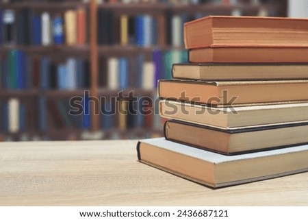 stack of books on a wooden table, library background