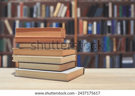 stack of books on a wooden table, library background