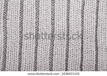 The texture of a knitted woolen fabric gray, culinary surface. Background
