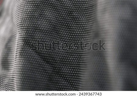 Texture of a grey piece of clothing. It has futuristic round patterns, creating the image of an alluminium sheet.