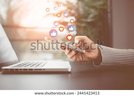 Social media and digital online concept. Person using a social media marketing on mobile phone with notification icons of like, message, comment and star above smartphone screen. Phone Social media.