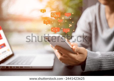 Social media and digital online concept. Person using a social media marketing on mobile phone with notification icons of like, message, comment and star above smartphone screen. Phone Social media.