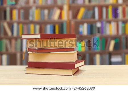 stack of books on wooden table against blurred background. space for text