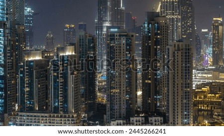 Aerial cityscape timelapse at night with illuminated modern architecture in Downtown of Dubai, United Arab Emirates. Illuminated Financial district view from rooftop