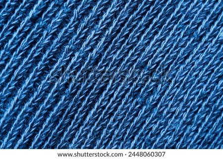 Background or backdrop of diagonally textured warm blue textile wool material. Cotton and wool. Photo. Macro. Close-up