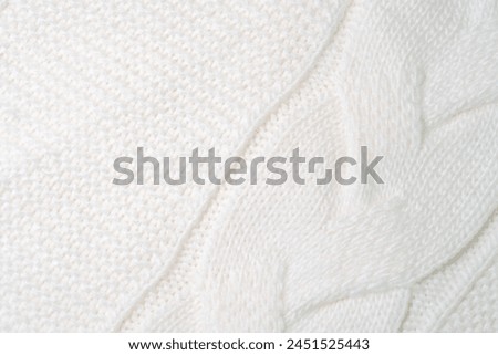 Detailed close up view of a white blanket, showing the texture and fabric of the material with a focus on its color and patterns.