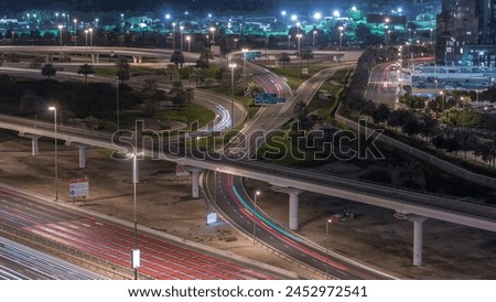 Aerial top view to intersection on Sheikh Zayed road near Dubai Marina and JLT night timelapse, Dubai. Traffic, bridges and metro line. United Arab Emirates