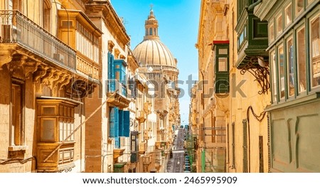 Sunny street in Valletta old town, Basilica of Our Lady of Mount Carmel on a background, Malta travel photo