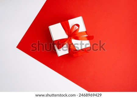 Gift box with a bow on a colored background. Happy Holidays, gift box close-up. Boxing Day surprise. Magic time. Wrapping paper, toys and ribbon