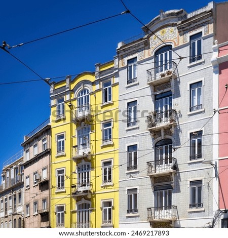 pastel-coloured and typically tiled residential buildings with the omnipresent overhead lines of the historic tramway in the Graça district of lisbon