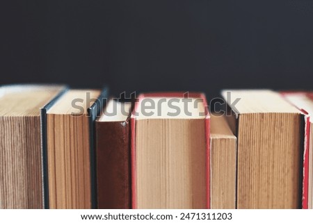 pile of books on the shelf, black background, education