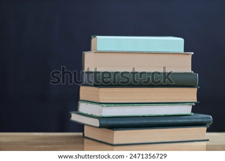 Green books on the table on black background
