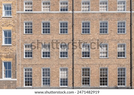 Facade of a brick building with a symmetrical arrangement of sash windows in London, England