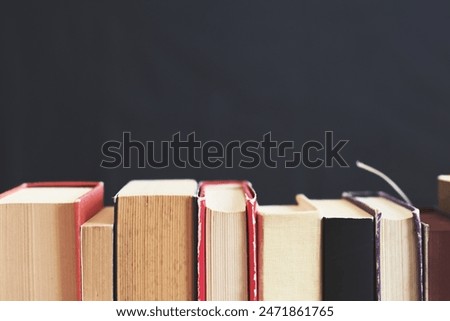 pile of books on the shelf, black background, education