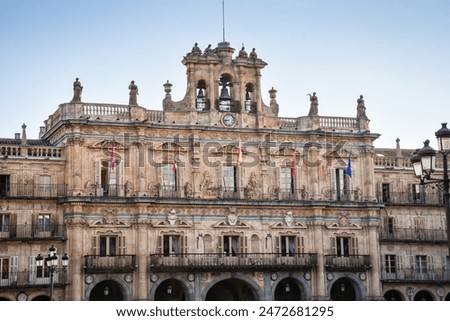 Ornate building and bell tower of one of the historic baroque buildings surrounding the Plaza Mayor of the Spanish city of Salamanca in morning light.